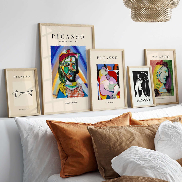 Gallery display of framed Picasso-inspired abstract art prints on a wall with decorative pillows.