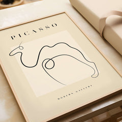 Picasso Camel Line Art Minimalist Animal Poster Modern Gallery Print Wall Art displayed in a wooden frame on a table.