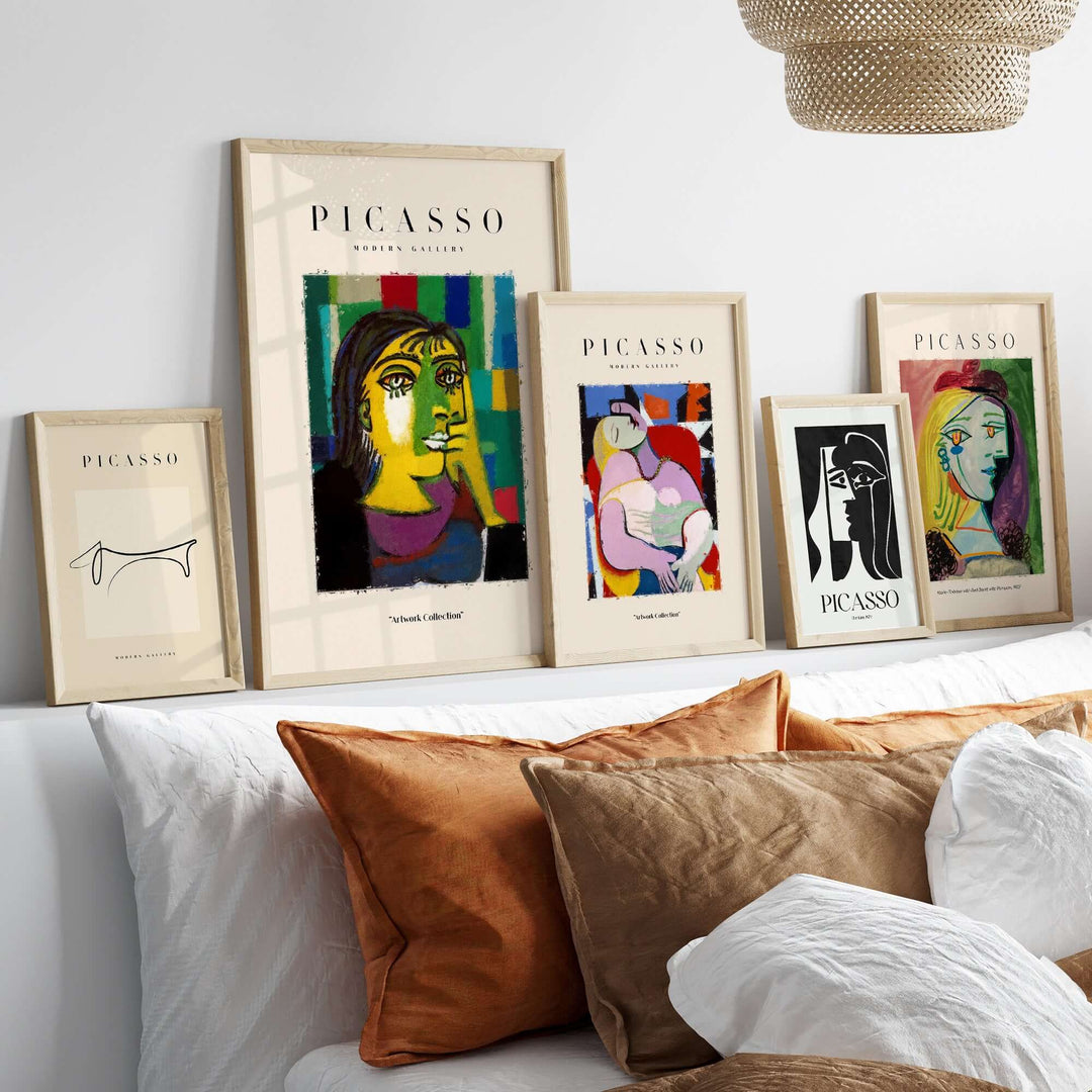 Framed Picasso-inspired art prints displayed on a cozy sofa, showcasing colorful abstract portraits and Cubist designs.