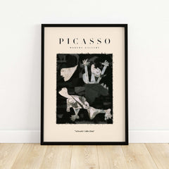 Picasso Guernica Inspired Falling Figures Art Print Abstract Black White Poster Collection in black frame on wooden floor.