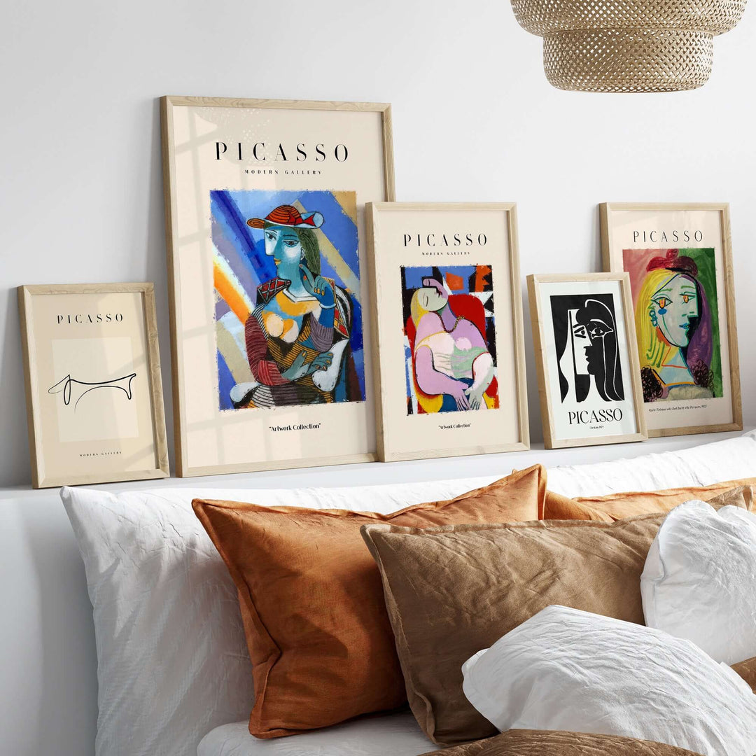 Display of Picasso-inspired framed artwork, featuring colorful portraits on a modern sofa with decorative pillows.