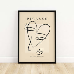 Picasso Line Art Abstract Heart Face Minimalist Modern Gallery Print Poster displayed in a black frame on a light wooden floor.
