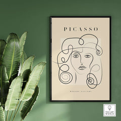 Picasso Woman Curly Hair Line Art Abstract Portrait Poster Modern Gallery Wall Art displayed on a wall with green plants.