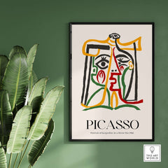 Picasso Portrait Jacqueline Straw Hat 1962 Abstract Line Art Print Colorful Poster on a green wall with plants.