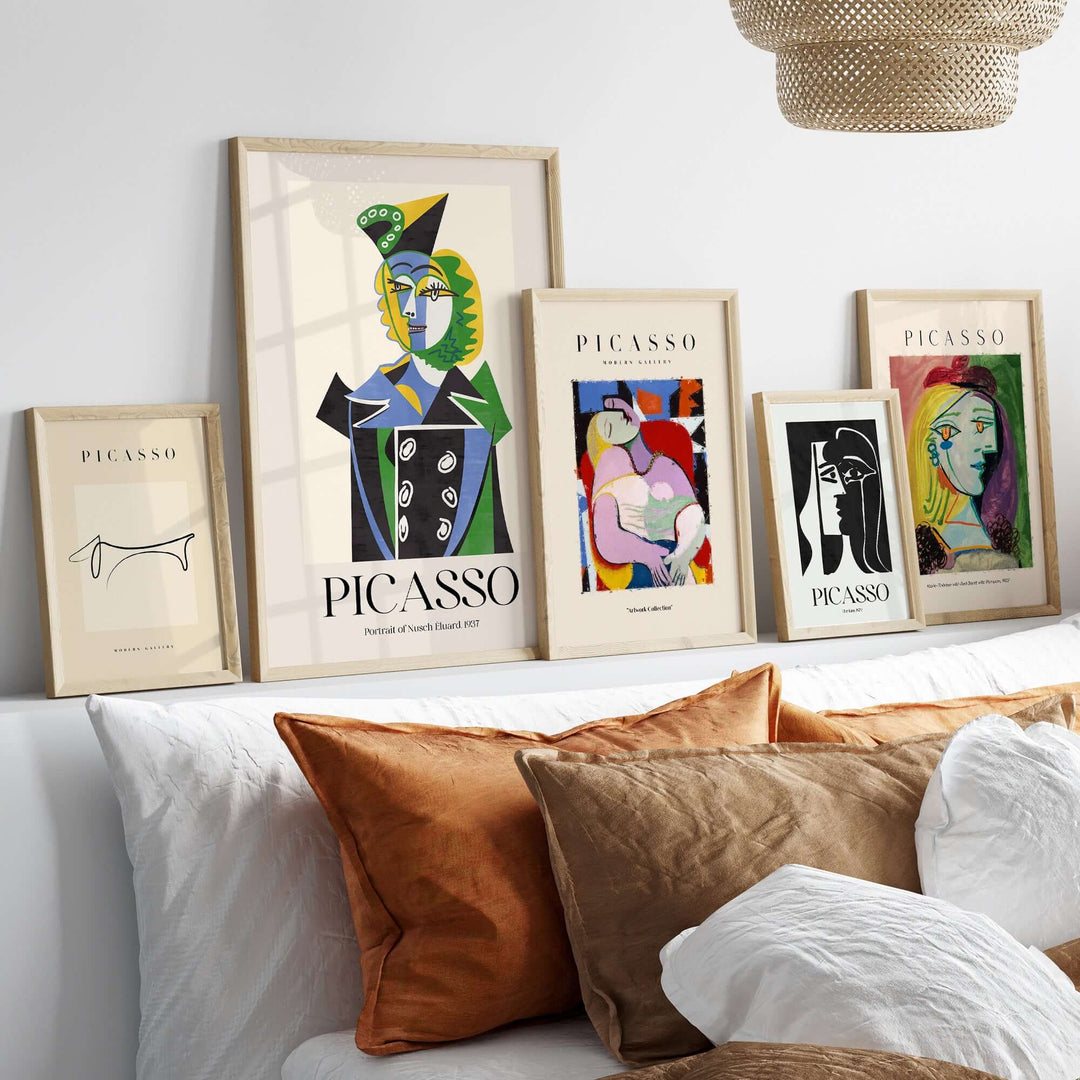 Collection of Picasso art prints featuring colorful Cubist designs in modern frames on a stylish shelf.