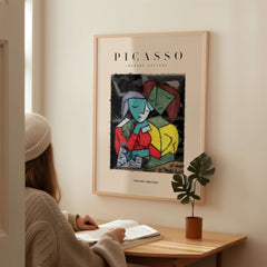 Picasso Reading Couple Abstract Figures Art Print Cubist Poster Artwork Collection displayed on a wall above a person reading.