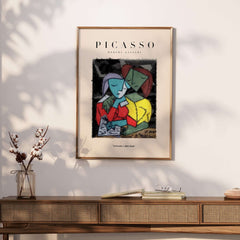 Picasso Reading Couple Abstract Figures Art Print Cubist Poster Artwork Collection framed on a wall above a wooden table.