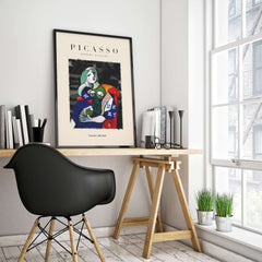 Picasso Seated Woman Reading Abstract Figure Art Print Modern Gallery Artwork Poster displayed on a desk against a bright room backdrop.