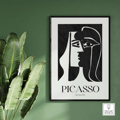 Picasso The Kiss 1979 Black White Abstract Profile Poster Art Print Wall Decor framed on a green wall with plants.