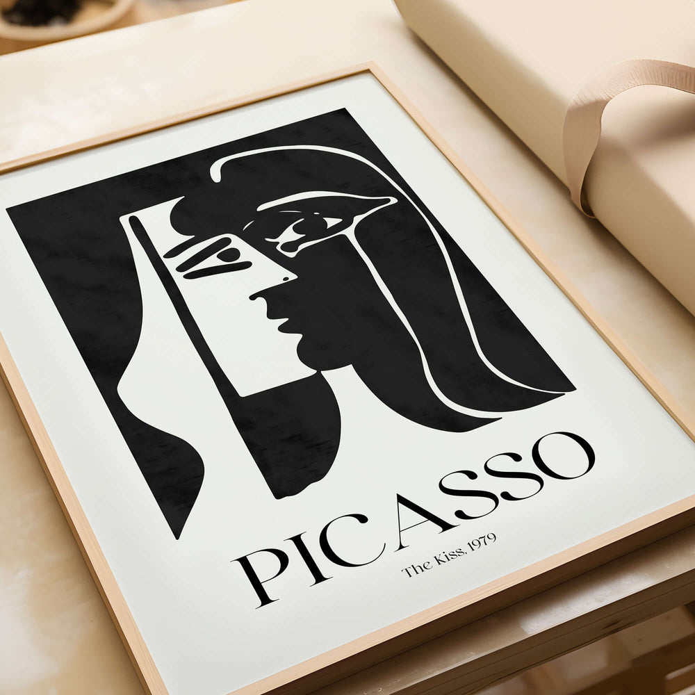 Picasso The Kiss 1979 Black White Abstract Profile Poster Art Print Wall Decor framed art print on a table.