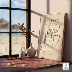 Picasso Two Faces Abstract Profiles Line Art Modern Gallery Poster Wall Art Print displayed on a wooden shelf by a window.
