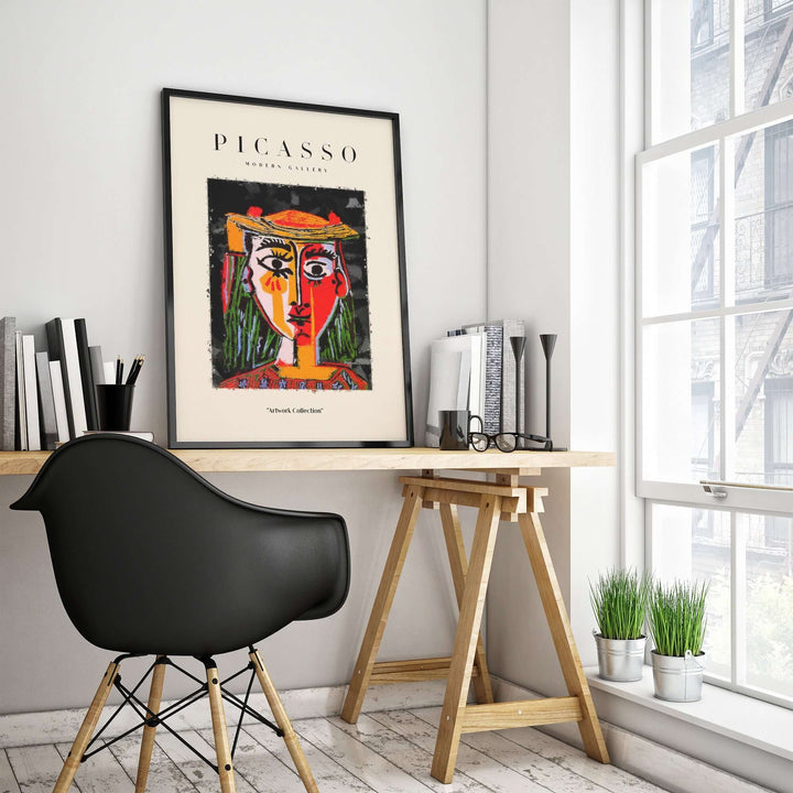 Picasso-inspired colorful abstract portrait of a woman in hat, framed in modern workspace with desk and chair.