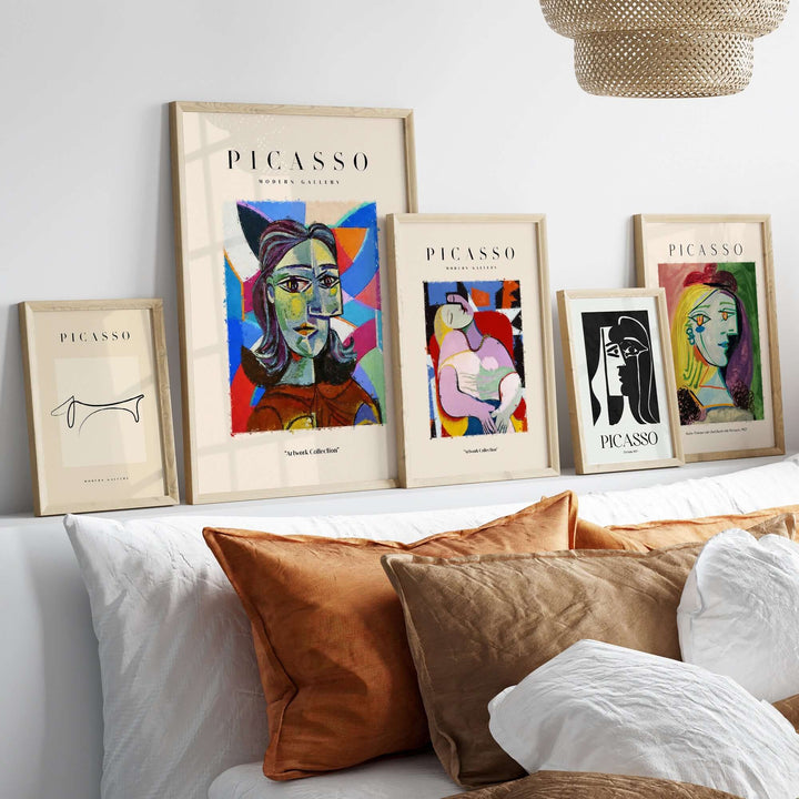Collection of Picasso-inspired colorful abstract art prints displayed on a sofa with decorative cushions.