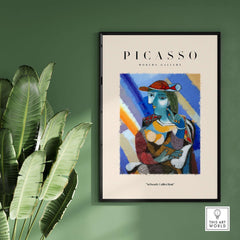 Picasso Woman Red Hat Blue Face Portrait Print Colorful Cubist Poster Artwork Collection framed on wall with green background.
