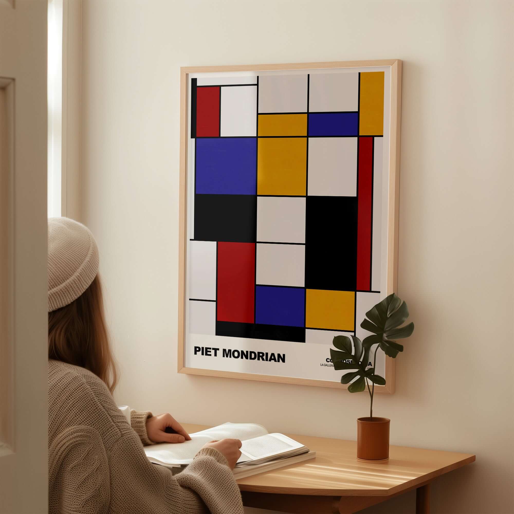Piet Mondrian Composition A Geometric Abstract Art Print De Stijl Poster Wall Decor displayed on wall with a person reading.