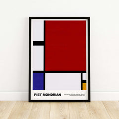 Piet Mondrian Composition Red Blue Yellow 1930 Abstract Art Print Poster Geometric in a black frame on wooden floor.