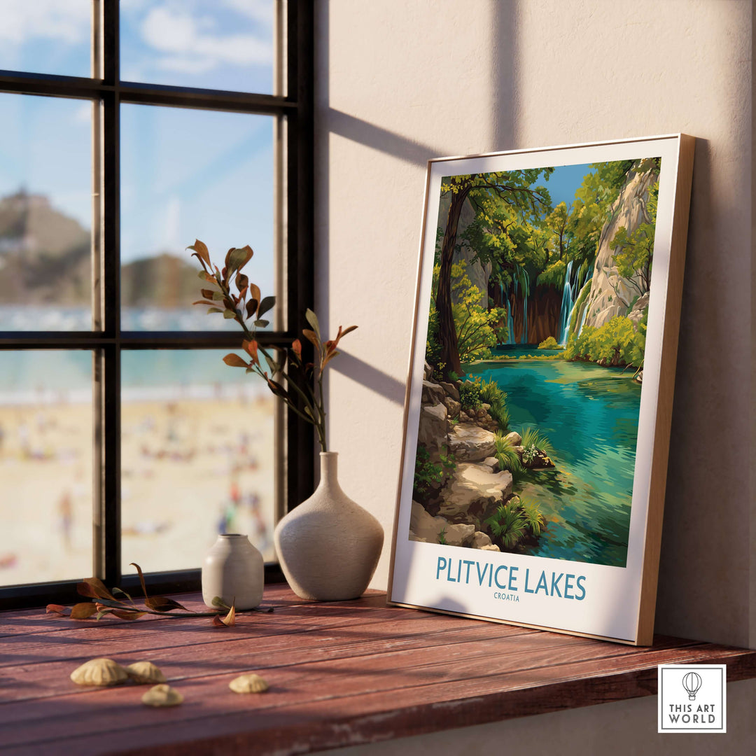 Framed Plitvice Lakes travel poster showcasing turquoise waters and lush scenery, displayed near a sunny window.