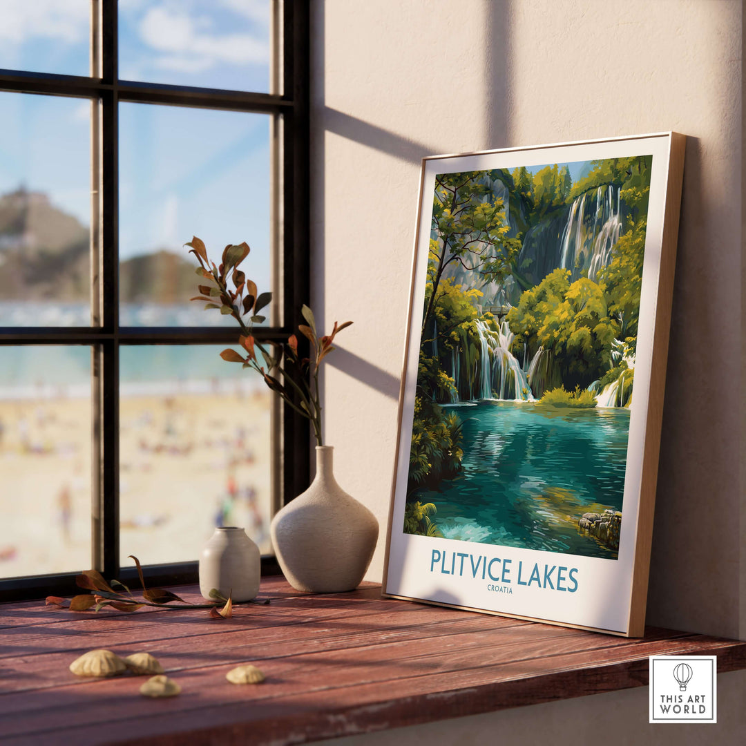 Plitvice Lakes waterfall poster displayed on a windowsill, featuring vibrant colors of Croatia's national park.