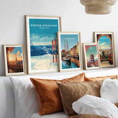 Pocono Mountains ski resort poster and travel prints displayed on a cozy bed with decorative pillows.