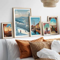 Framed Pocono Mountains ski run poster among various art prints on a stylish bed with cozy pillows.