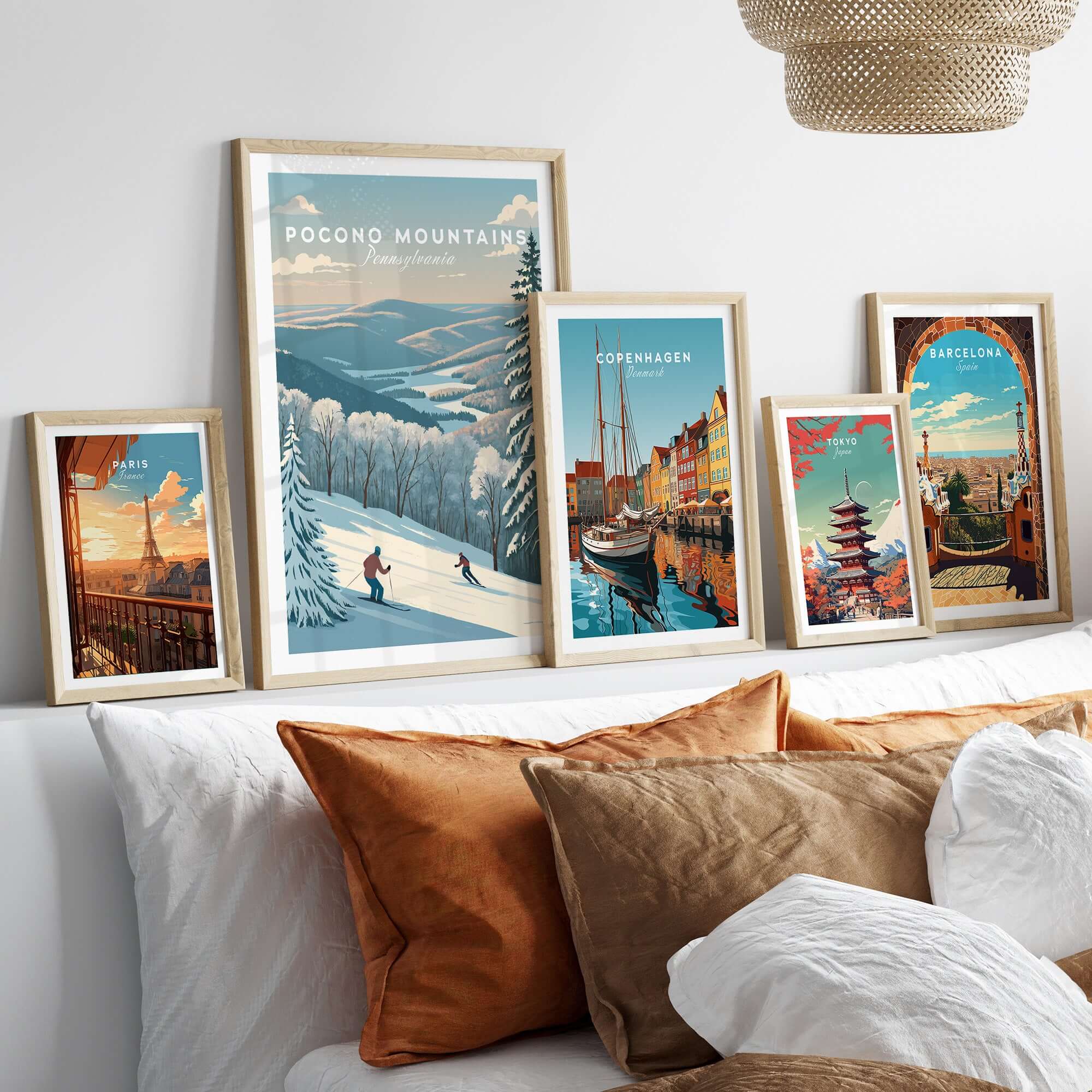 Framed Pocono Mountains ski run poster among various art prints on a stylish bed with cozy pillows.