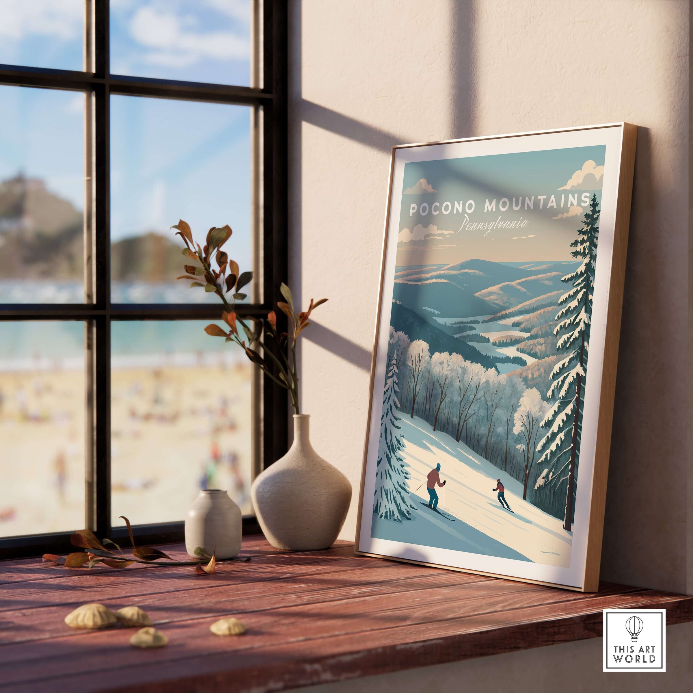 Pocono Mountains Pennsylvania ski run poster displayed on a windowsill with a scenic beach view behind it.