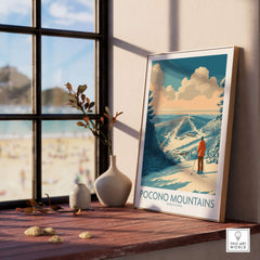 Pocono Mountains Ski Poster displayed on a wooden shelf near a window, capturing winter essence and scenic beauty.