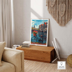 Poster of Amsterdam with bike and tulips on display in cozy living room, adding vibrant energy and charm to the decor.