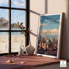 Pristina City View Canvas Print | Kosovo Urban Wall Decor displayed on a windowsill with a beach view.