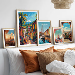 Puerto Vallarta Travel Poster set among various city travel posters framed on a couch with decorative cushions.