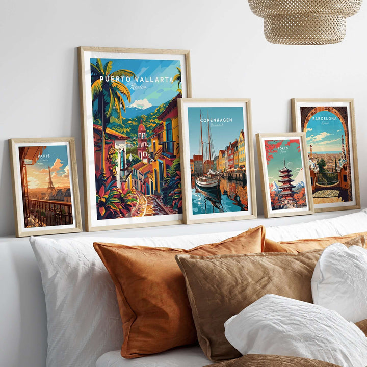 Collection of vibrant travel posters including Puerto Vallarta, Copenhagen, and Barcelona, displayed above a cozy, modern-styled couch.