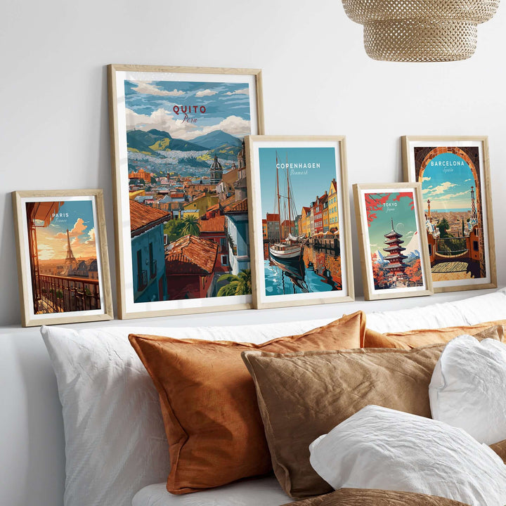 Quito Ecuador travel print and cityscape posters displayed on a wall above a couch with decorative pillows.