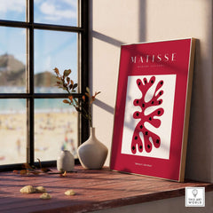 Matisse Art Prints - Red Coral Abstract Black Diamonds Poster displayed on a shelf near a window.