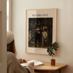 Rembrandt The Night Watch 1642 Famous Dutch Master Painting Art Print Poster displayed on a wall in a cozy room.