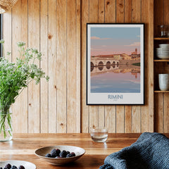 Rimini Italy Poster | Panoramic River Cityscape Scene Canvas Print displayed on wooden wall with plants and bowls.