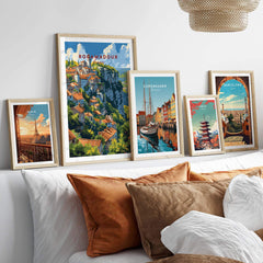 Framed Rocamadour travel poster among other city posters on a cozy sofa setting, highlighting French charm and travel aesthetic.