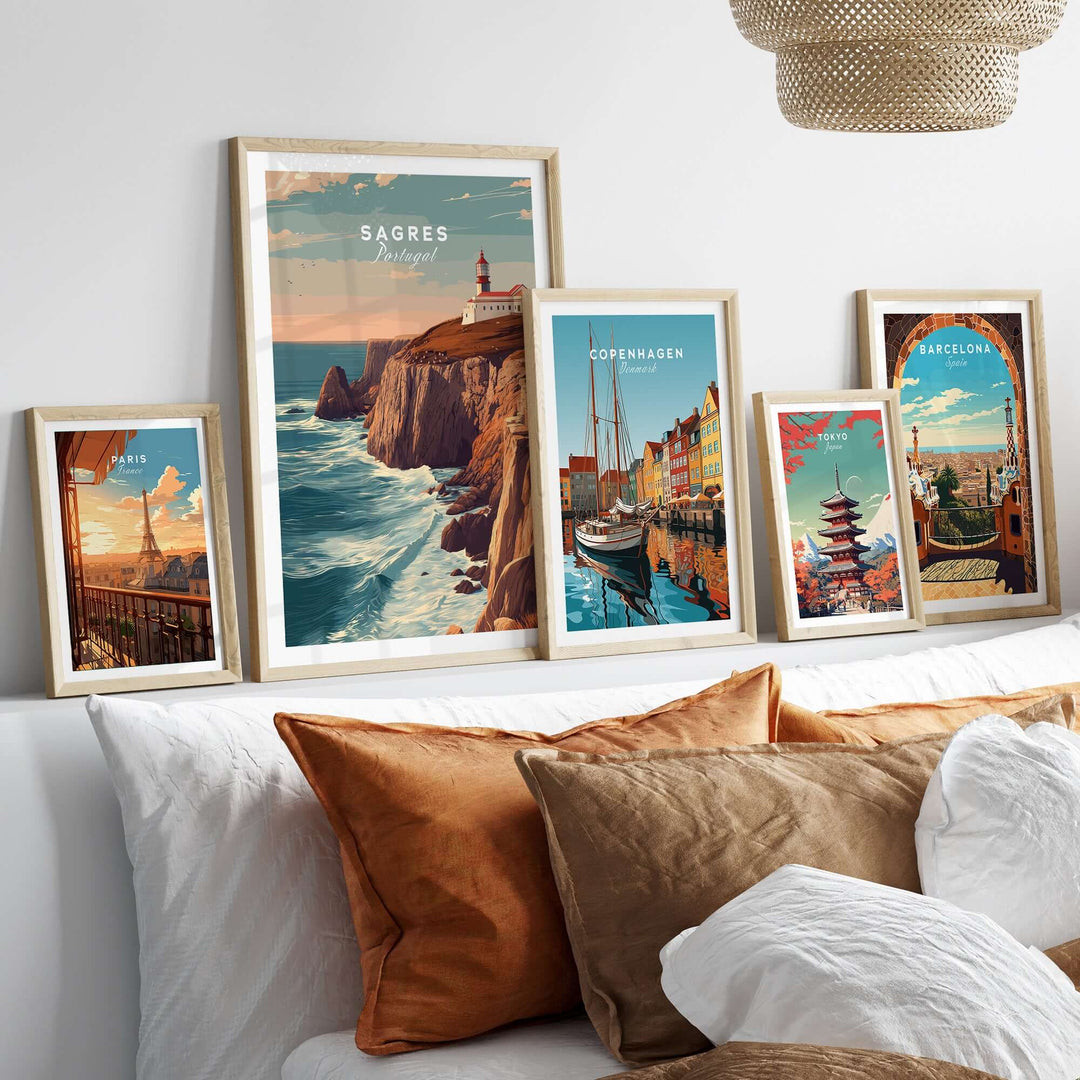 Sagres Poster - Wild Algarve Coastline View Print displayed among other travel-themed artworks on a cozy sofa.