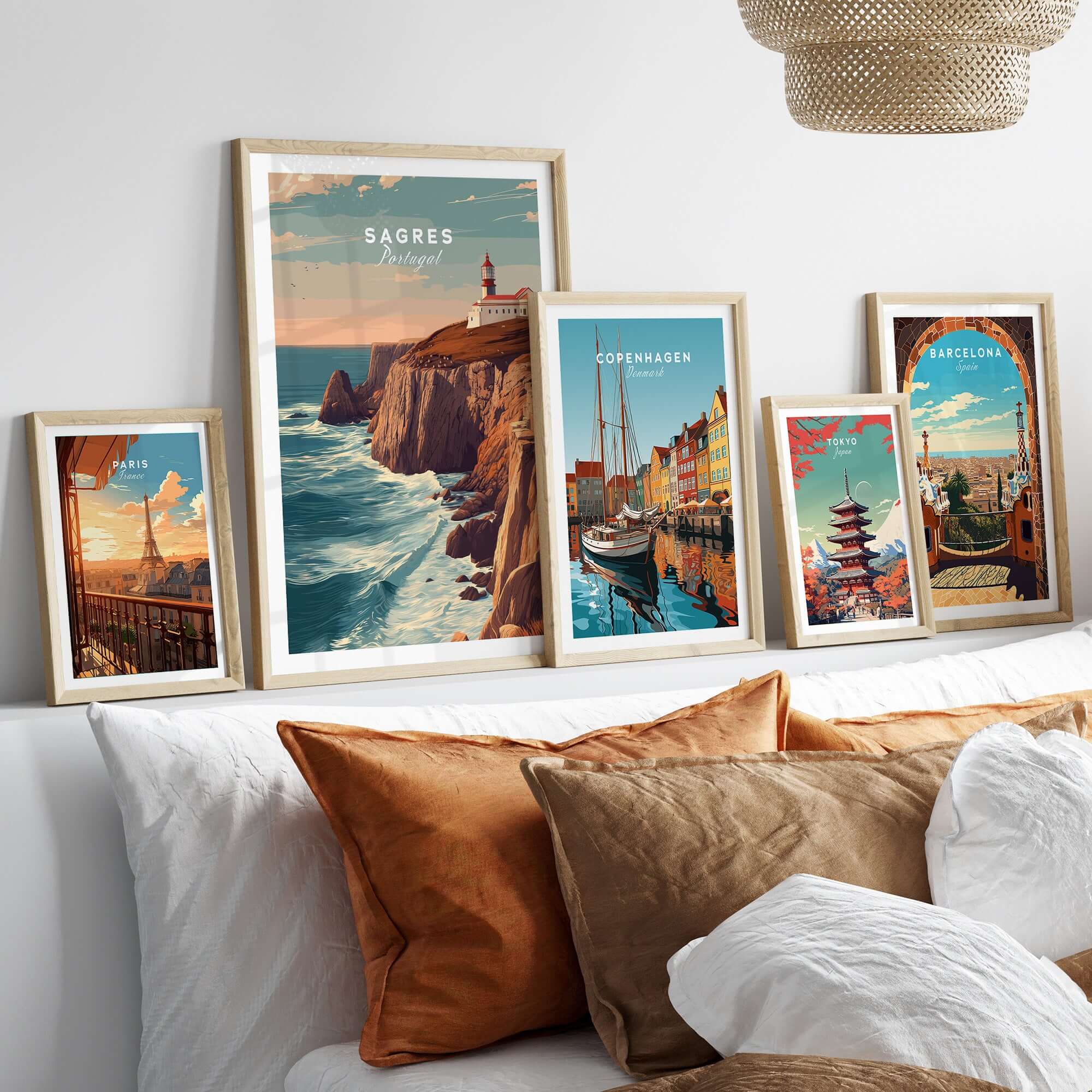 Sagres Poster - Wild Algarve Coastline View Print displayed among travel prints on a cozy sofa.