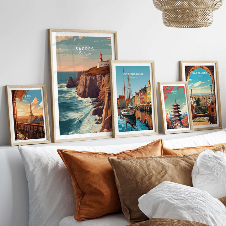 Sagres Poster - Wild Algarve Coastline View Print displayed among other travel-themed artworks on a cozy sofa.
