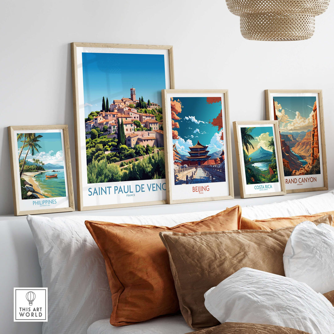 Saint Paul de Vence travel poster and other international art prints displayed in stylish frames on a cozy sofa.