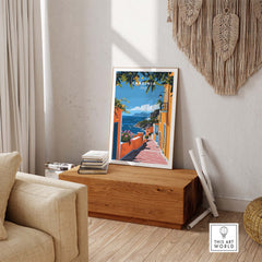 Sardinia Art Print - Coastal Landscape Wall Decor displayed in a cozy living room setting, showcasing vibrant coastal colors.