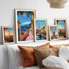 Sardinia Art Print - Coastal Landscape Wall Decor displayed among framed travel posters on a stylish bed.
