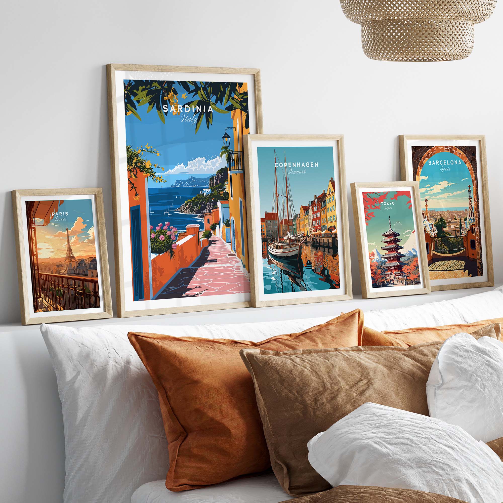 Sardinia Art Print - Coastal Landscape Wall Decor displayed among framed travel posters on a stylish bed.