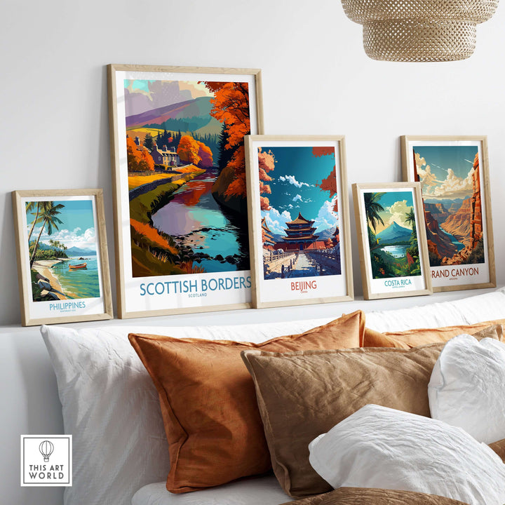 Framed travel posters, including Scottish Borders, depicting scenic landscapes from around the world on a cozy sofa.