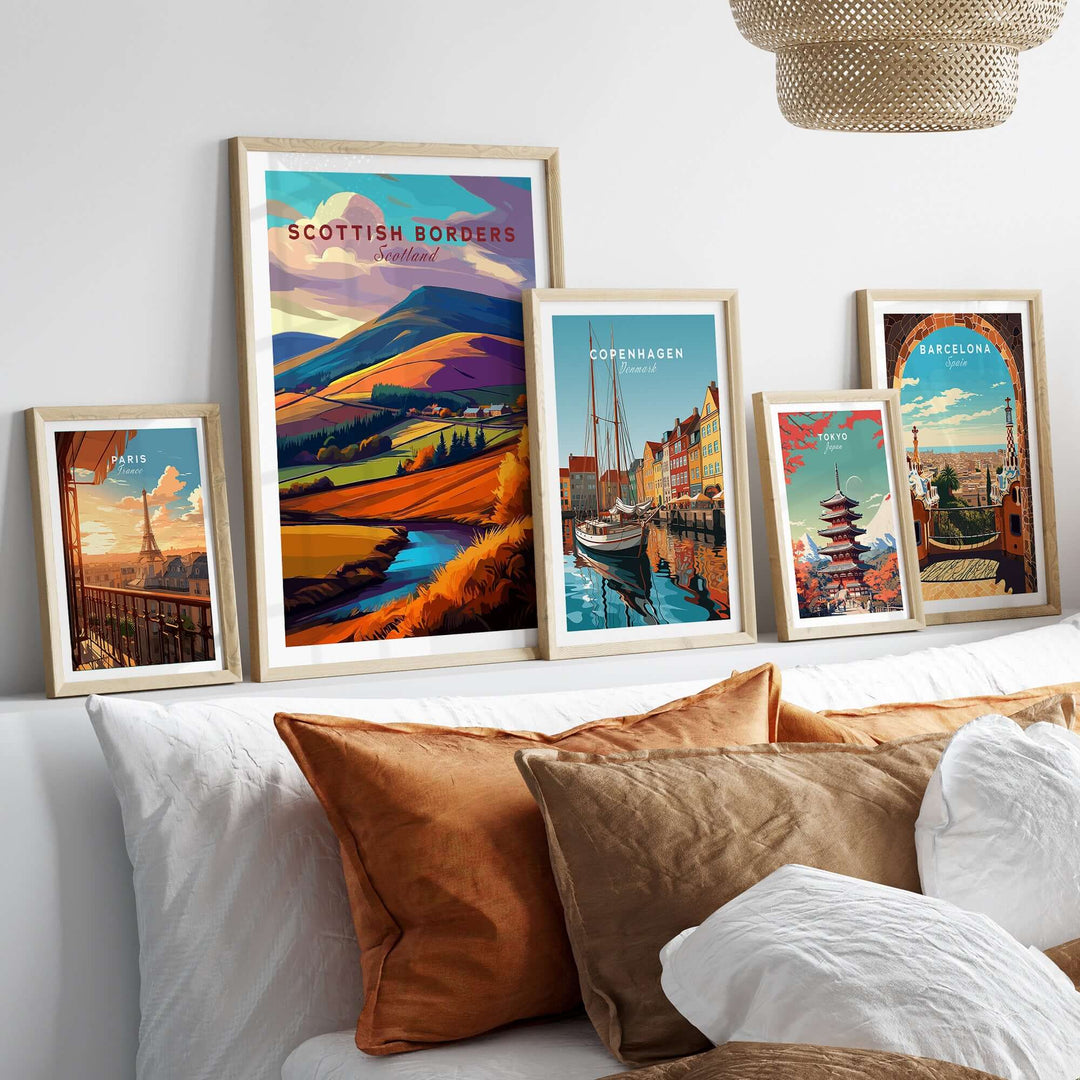Scottish Borders Valley travel print and other city posters displayed on a stylish sofa, showcasing vibrant landscapes.