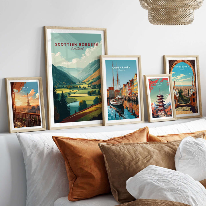 Wall art featuring Scottish Borders landscape print among other travel posters, displayed on a cozy bed.