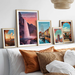 Seljalandsfoss Poster Iceland Wall Art displayed among framed travel posters on a stylish couch.