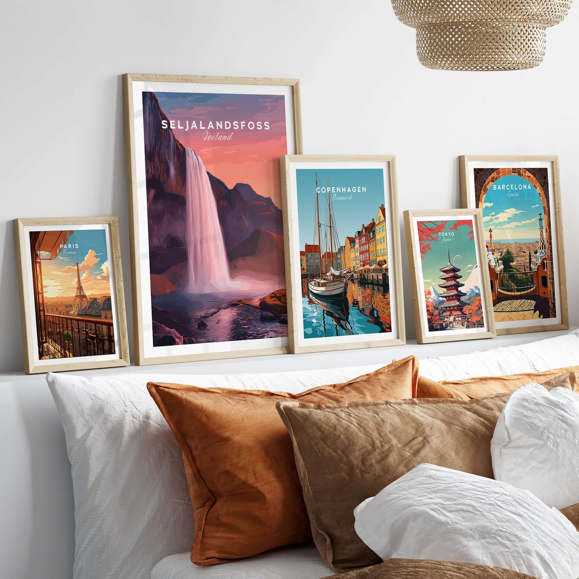 Seljalandsfoss Poster Iceland Wall Art displayed among framed travel posters on a stylish couch.