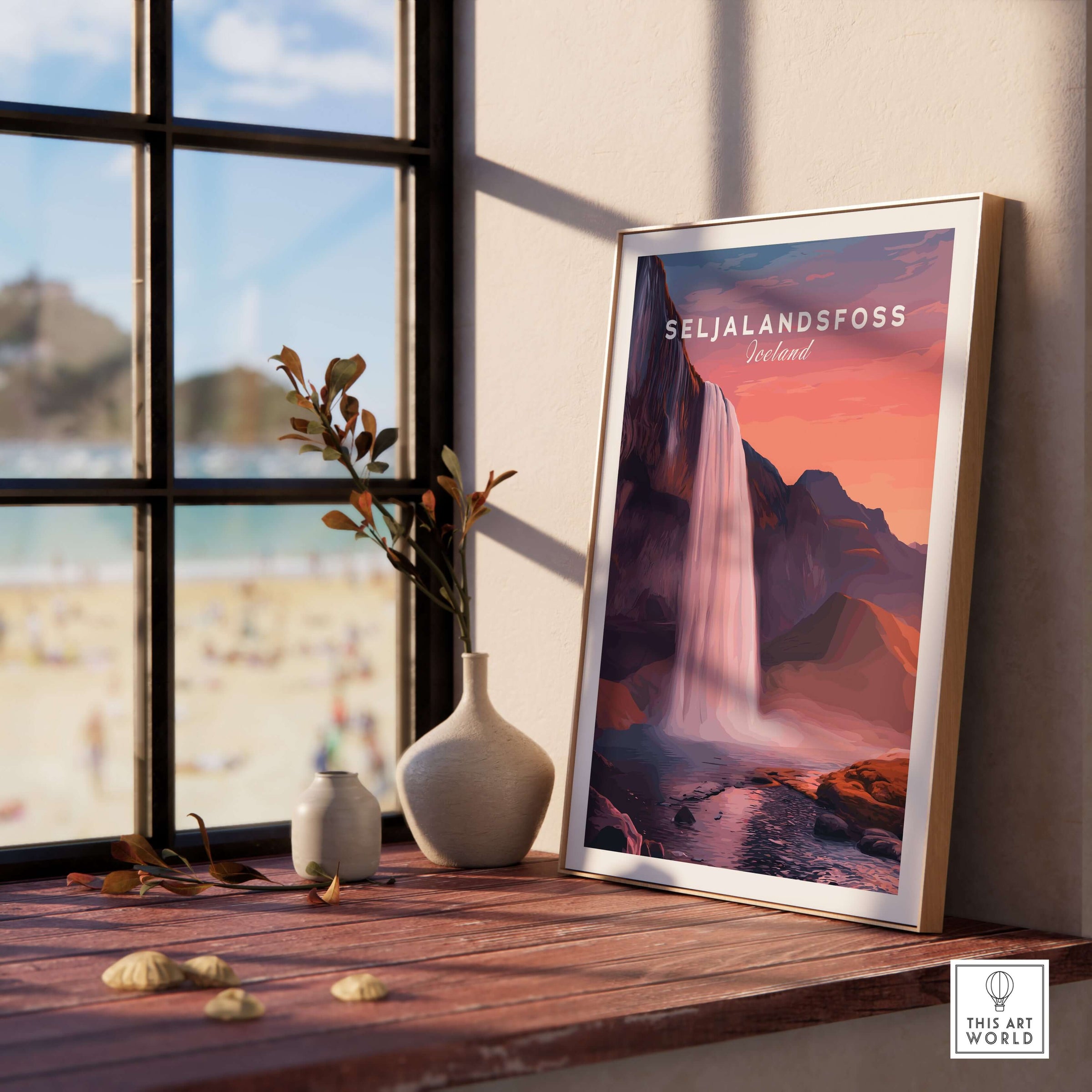 Seljalandsfoss Poster Iceland Wall Art displayed in a sunny room by the window with a beach view.