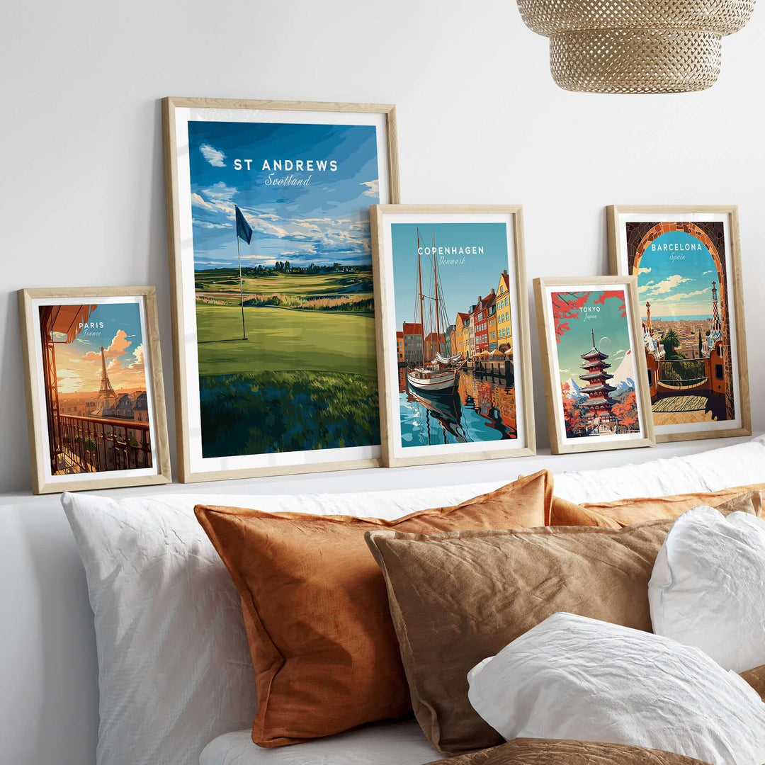 St Andrews poster among framed travel prints on a stylish bed, showcasing iconic landscapes and culture.